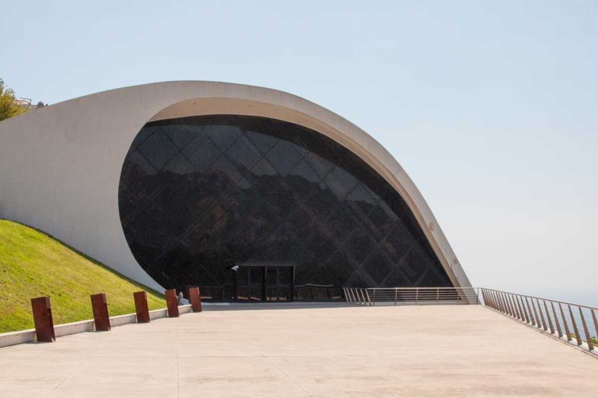 Scorcio del parcheggio Auditorium Oscar Niemeyer con auto, navetta in partenza e sfondo sul mare di Ravello